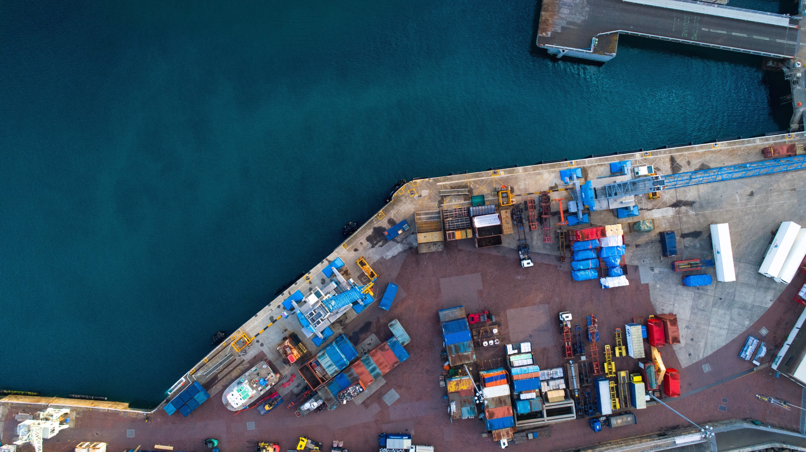 Vista aérea de un terminal portuario de carga genérico en Chile, operando como hub intermodal en el marco del Programa de Desarrollo Logístico del MTT para potenciar el transporte multimodal.